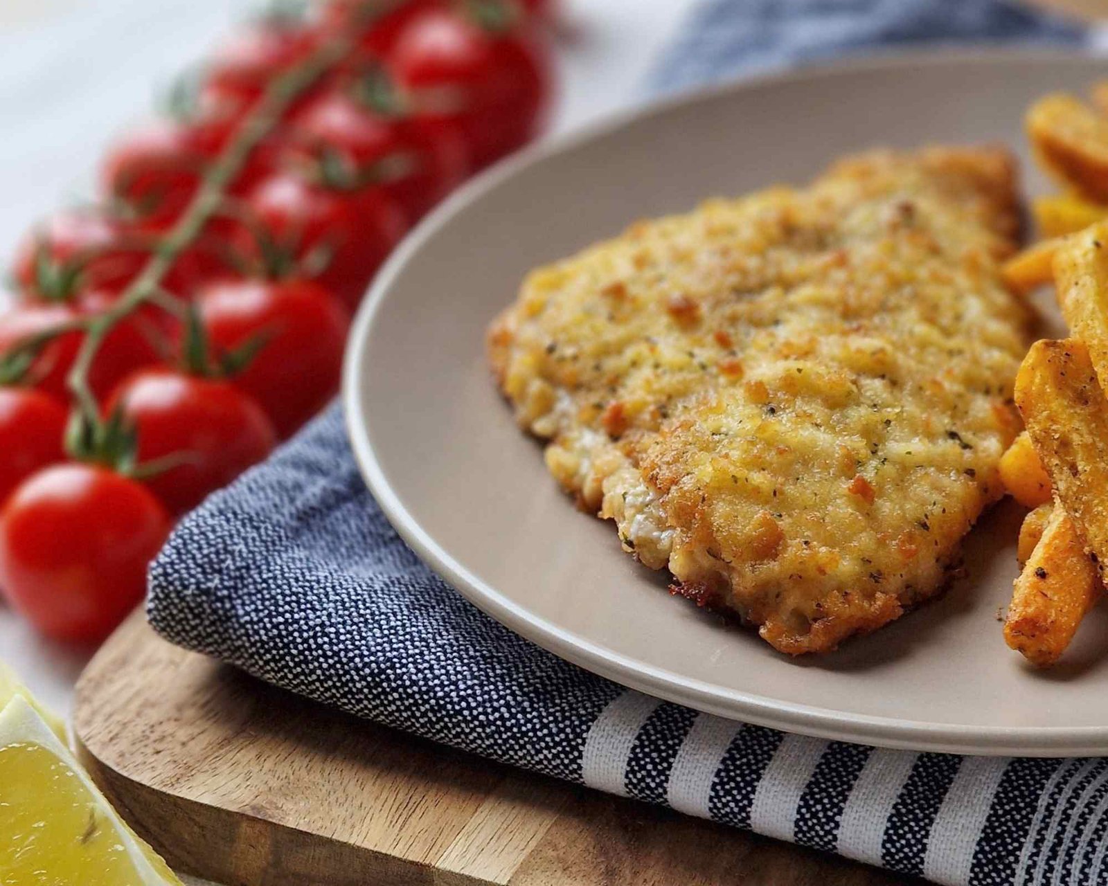 una cotoletta di pesce con contorno di patate
