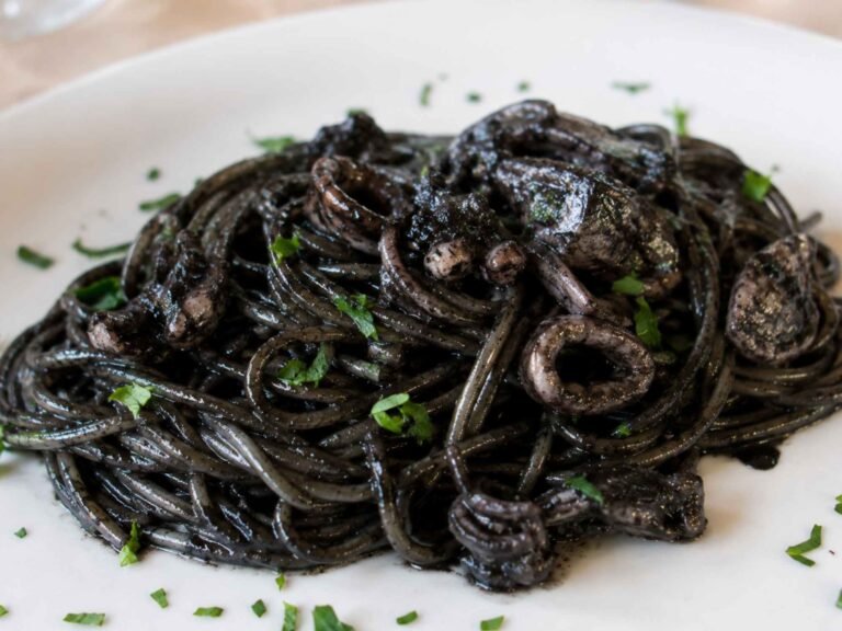 spaghetti conditi con sugo al nero di seppia in un piatto